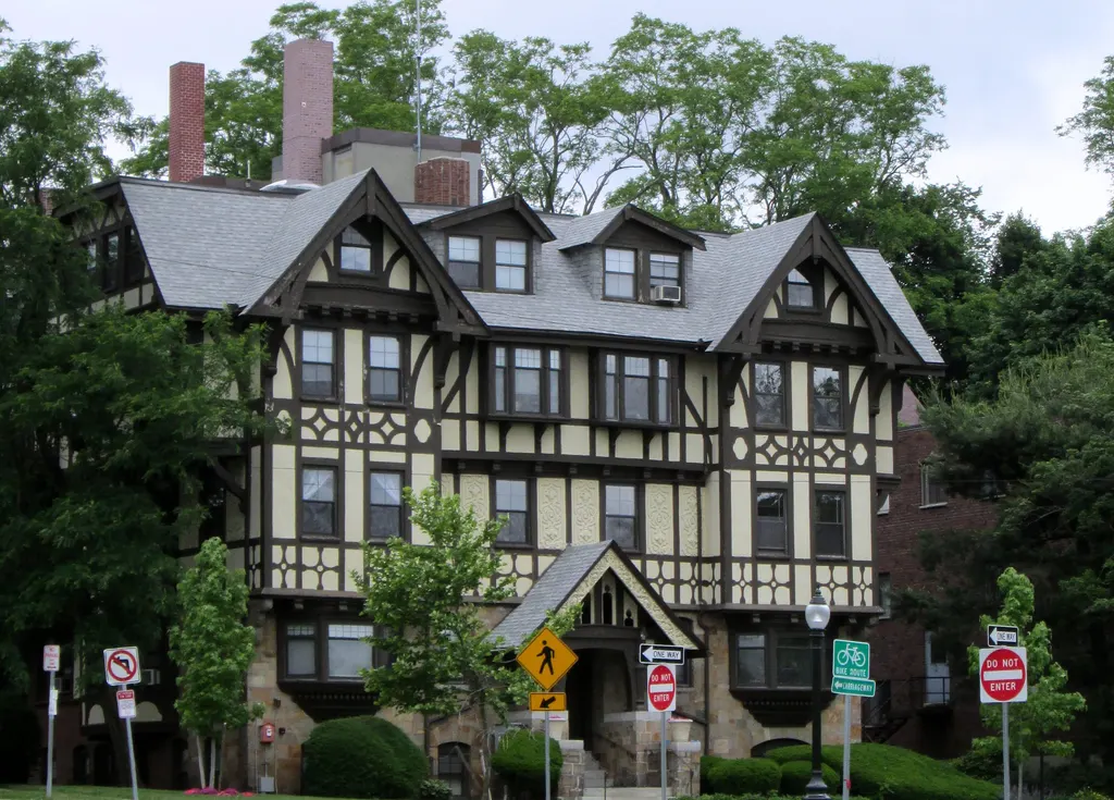 Large Tudor revival house in Newton with a slate roof and multiple gabled dormers